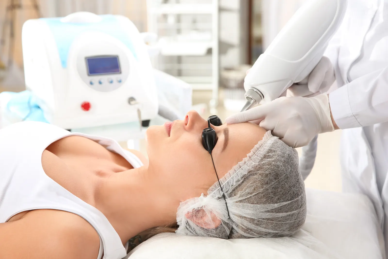 A facial laser session in progress, eye protection on and the laser unit nearby
